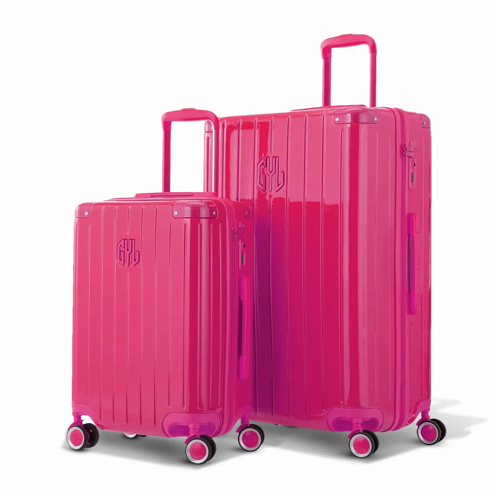 Duo of GYL Intemporelle fuchsia rigid suitcases with ribbed shells and telescopic handles. #color_fuchsia