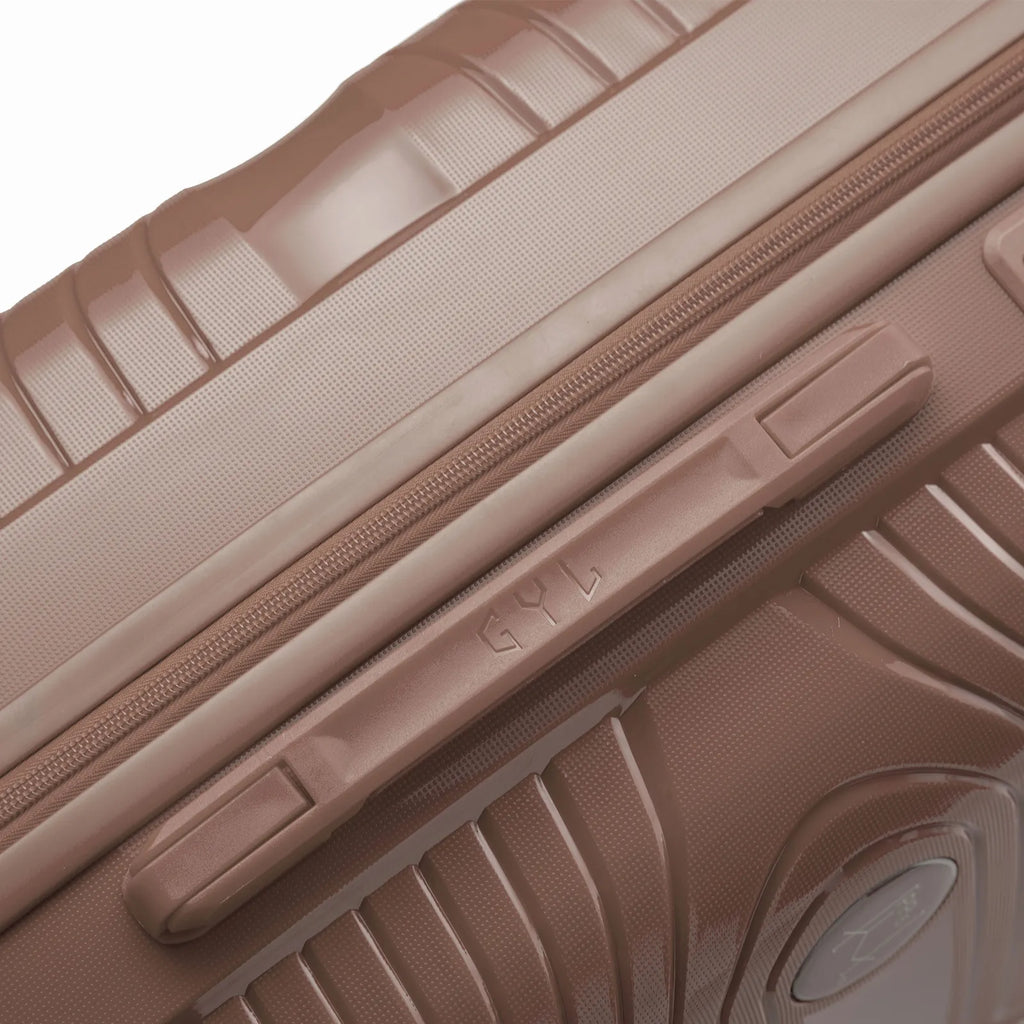 Détail de la poignée latérale et du logo GYL sur la valise Signature champagne. #couleur_champagne