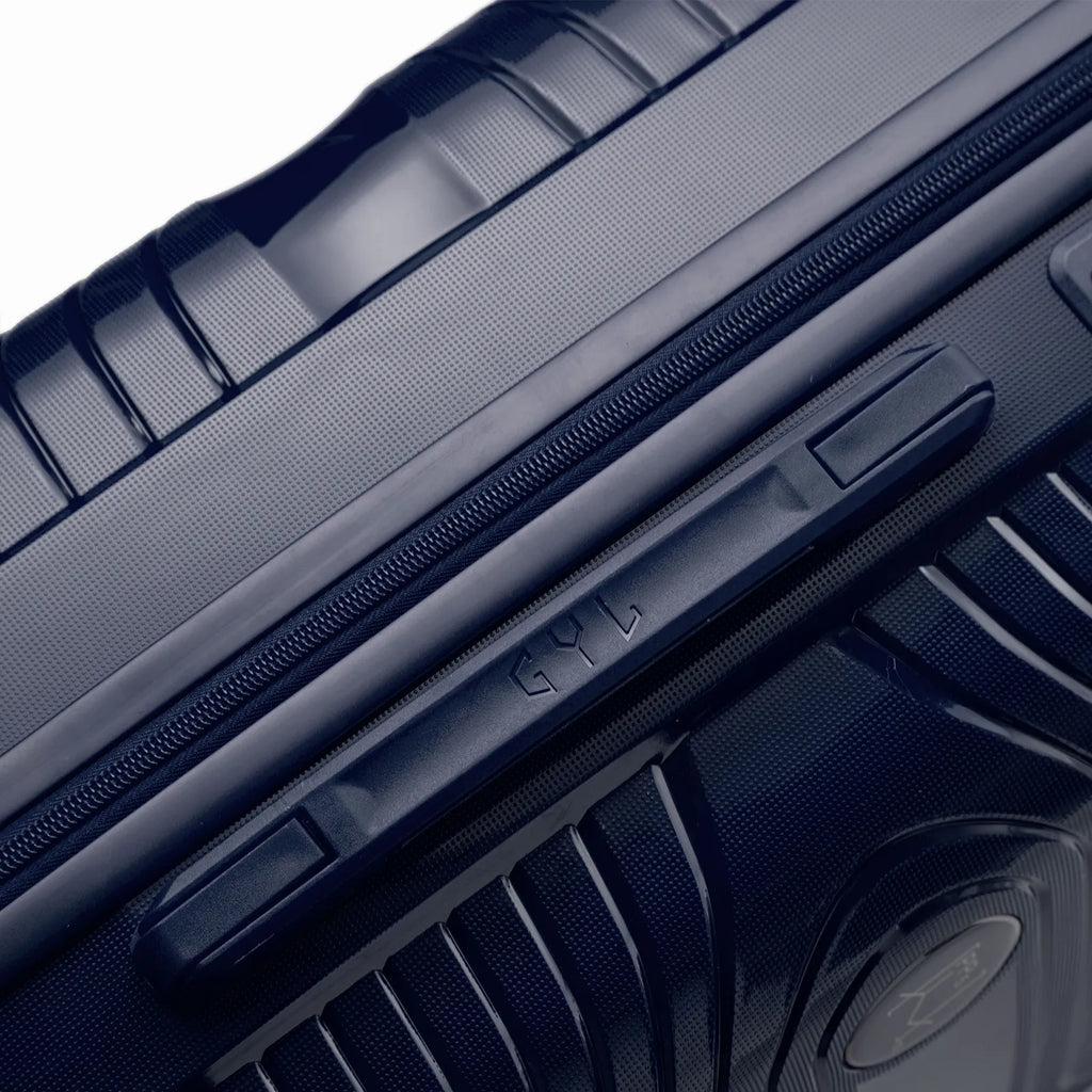Détail de la poignée latérale et du logo GYL sur la valise Signature marine. #couleur_marine