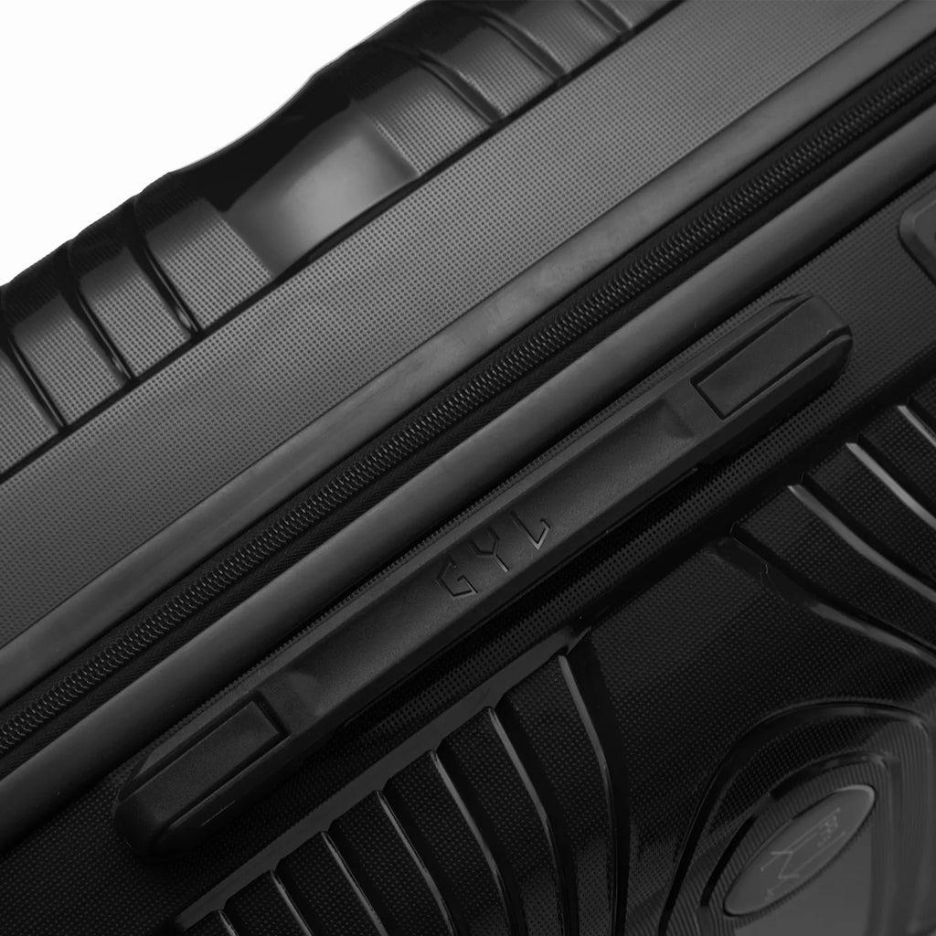 Détail de la poignée latérale et du logo GYL sur la valise Signature rouge. #couleur_noir