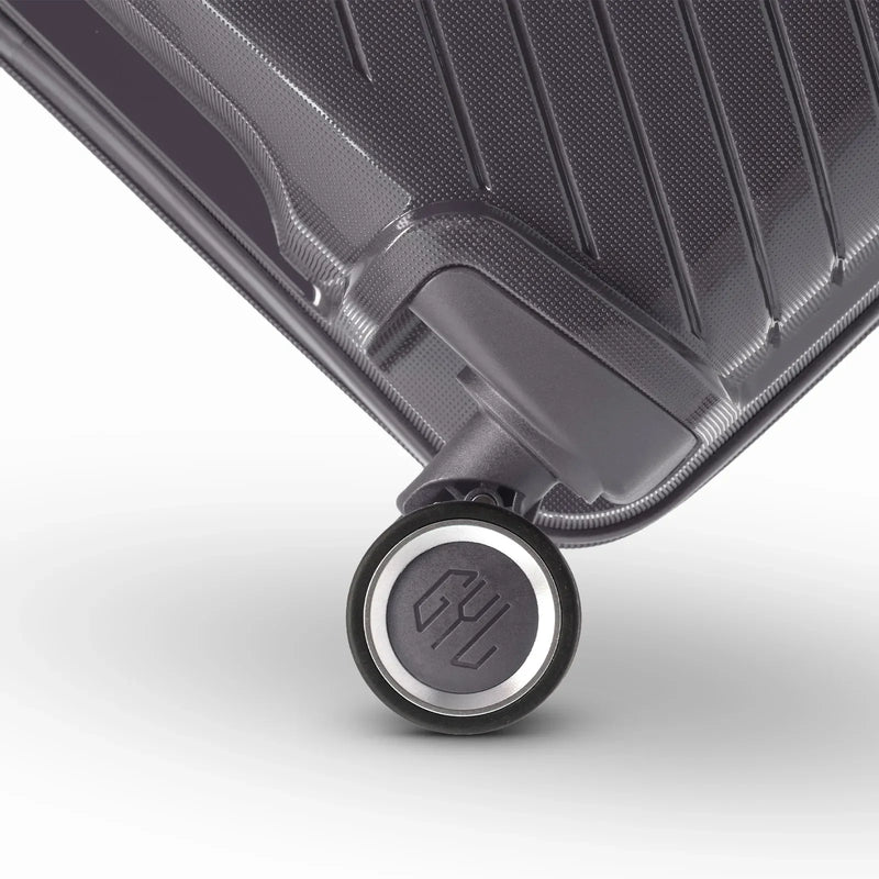Détail de la roue avec logo GYL sur la valise Signature argent en polypropylène brillant. #couleur_argent