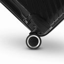 Détail de la roue avec logo GYL sur la valise Signature noire en polypropylène brillant. #couleur_noir