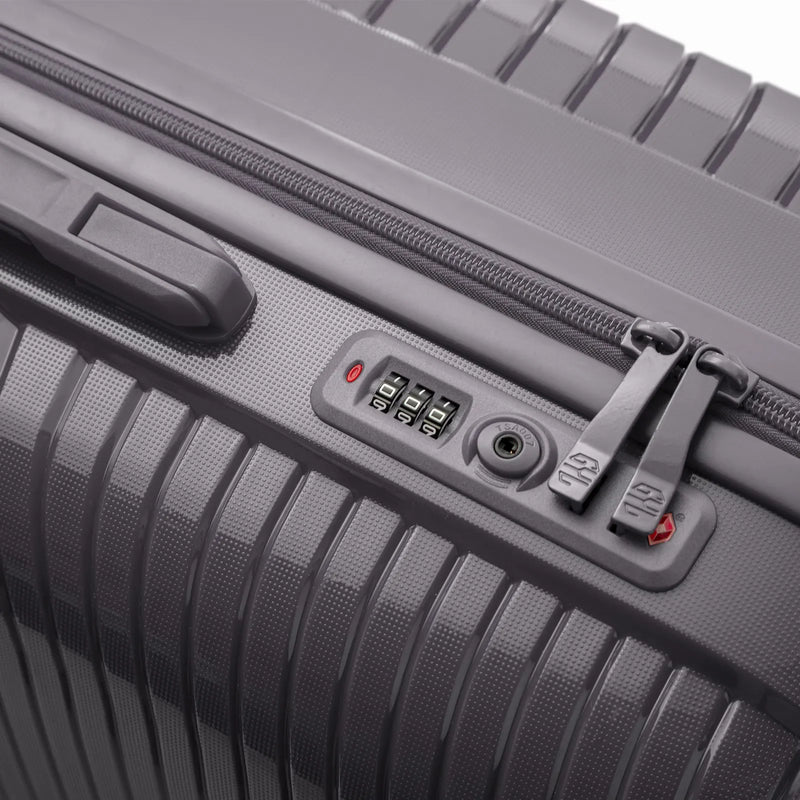 Détail de la serrure TSA intégrée et des curseurs sur la valise Signature argent. #couleur_argent