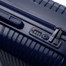 Détail de la serrure TSA intégrée et des curseurs sur la valise Signature marine. #couleur_marine