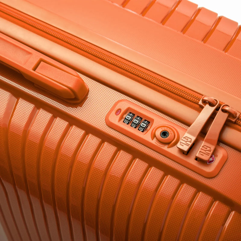 Detail of the integrated TSA lock and sliders on the orange Signature suitcase. #color_orange