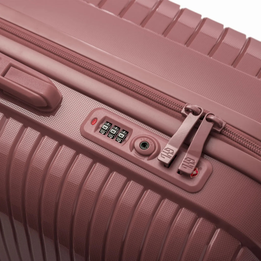 Détail de la serrure TSA intégrée et des curseurs sur la valise Signature rose gold. #couleur_rose gold