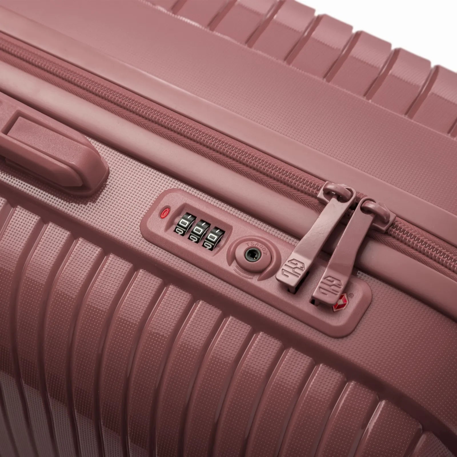 Détail de la serrure TSA intégrée et des curseurs sur la valise Signature rose gold. #couleur_rose gold