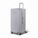 Valise trunk GYL taille XL en polycarbonate argent vue de trois quarts, avec trolley déployé et roues 360°. #couleur_argent