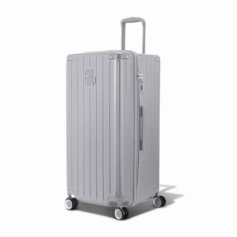 Valise trunk GYL taille XL en polycarbonate argent vue de trois quarts, avec trolley déployé et roues 360°. #couleur_argent