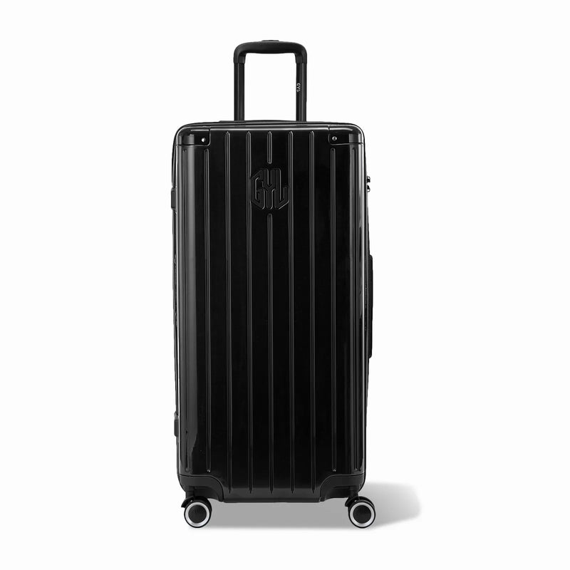 Maleta baúl GYL tamaño XL en policarbonato negro, vista frontal, con carro desplegado y ruedas de 360°.  #color_negro