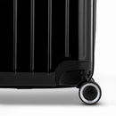 Détail de la roue et du logo GYL sur le bas de la valise trunk noir en polycarbonate brillant. #couleur_noir
