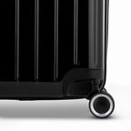 Détail de la roue et du logo GYL sur le bas de la valise trunk noir en polycarbonate brillant. #couleur_noir