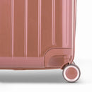 Detalle de la rueda y el logo GYL en la parte inferior de la maleta baúl de policarbonato brillante en color oro rosa. #color_oro rosa