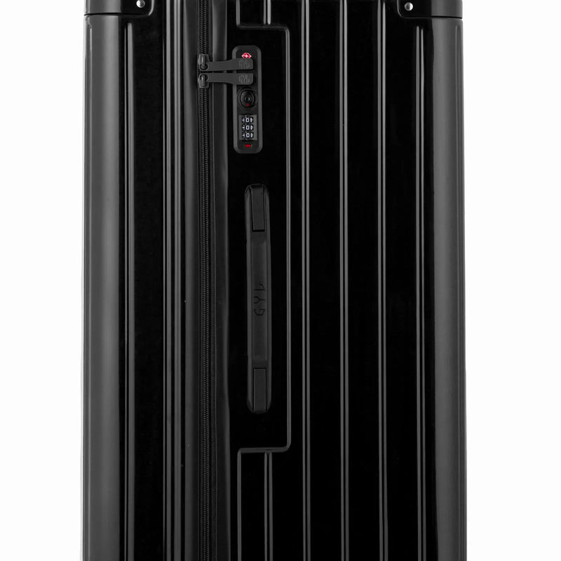 Detalle de la cerradura TSA y el asa lateral de la maleta baúl negra. #color_negro