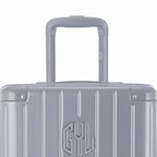 Zoom sur la poignée trolley et le logo GYL de la valise trunk argent. #couleur_argent
