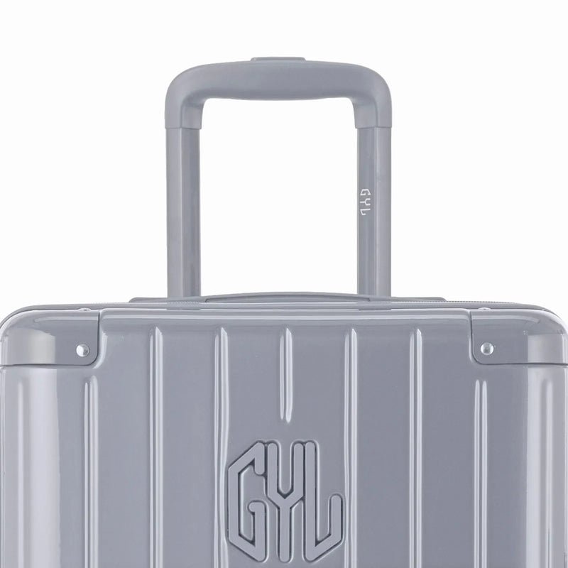 Zoom sur la poignée trolley et le logo GYL de la valise trunk argent. #couleur_argent