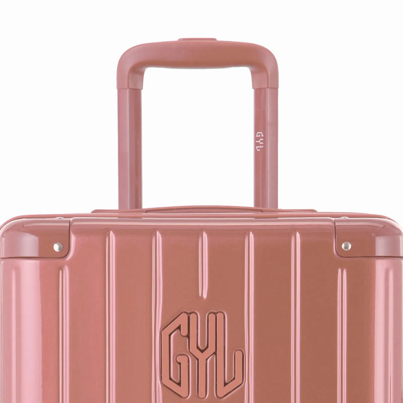 Haga zoom en el asa del carrito y el logo GYL de la maleta baúl en oro rosa. #color_oro rosa