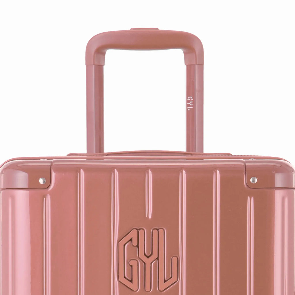 Zoom sur la poignée trolley et le logo GYL de la valise trunk rose gold. #couleur_rose gold