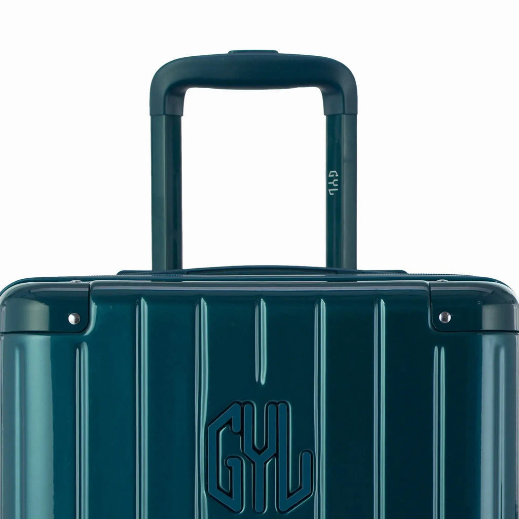 Zoom sur la poignée trolley et le logo GYL de la valise trunk sapin. #couleur_sapin
