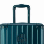 Zoom sur la poignée trolley et le logo GYL de la valise trunk sapin. #couleur_sapin