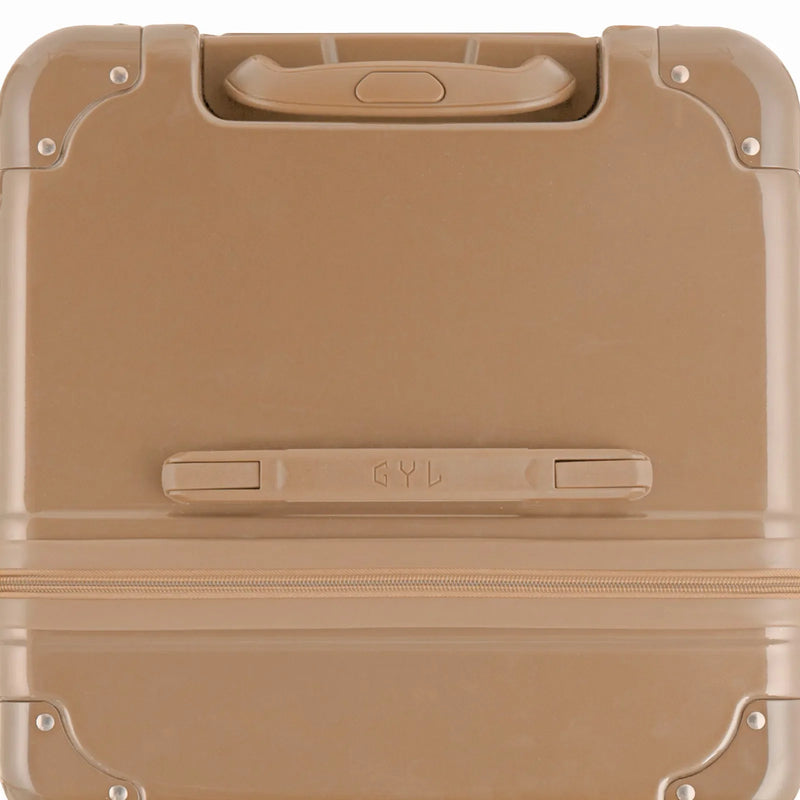Vue du dessus de la valise trunk GYL champagne en polycarbonate, avec poignée centrale et coins renforcés. #couleur_champagne