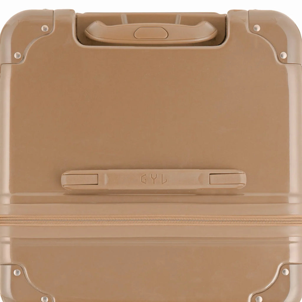 Vue du dessus de la valise trunk GYL champagne en polycarbonate, avec poignée centrale et coins renforcés. #couleur_champagne