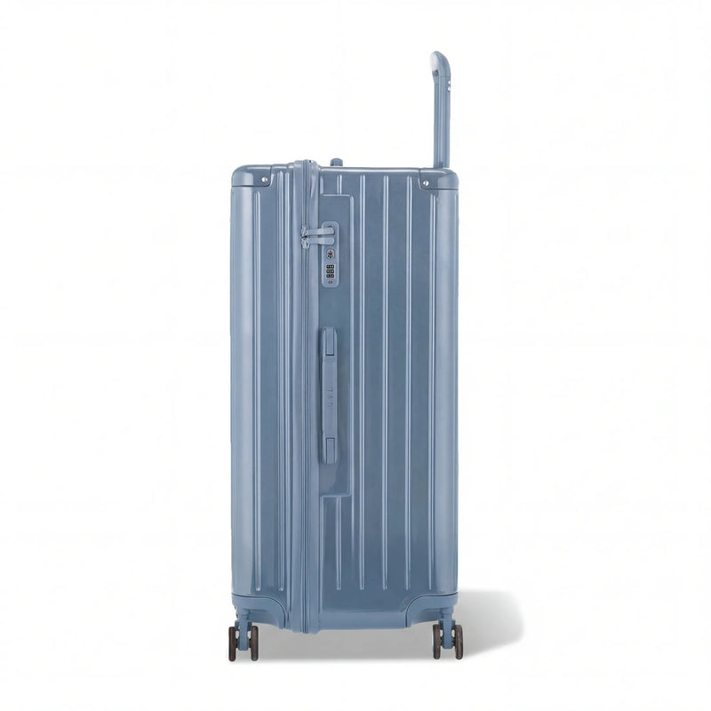 Dos de la valise trunk GYL XL bleu gris avec trolley télescopique sorti et logo embossé. #couleur_bleu grisé