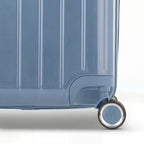 Détail de la roue et du logo GYL sur le bas de la valise trunk bleu gris en polycarbonate brillant. #couleur_bleu grisé