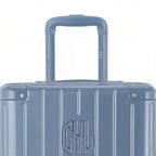 Zoom sur la poignée trolley et le logo GYL de la valise trunk bleu gris. #couleur_bleu grisé