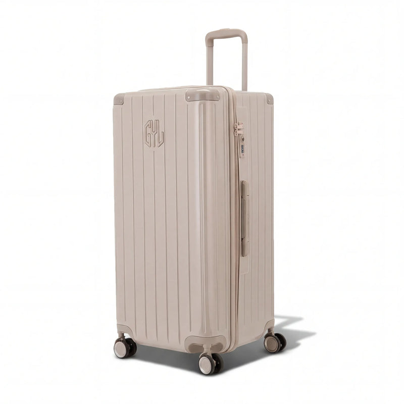 Valise trunk GYL taille XL en polycarbonate nude vue de trois quarts, avec trolley déployé et roues 360°. #couleur_nude