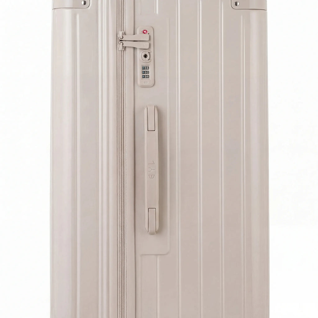 Détail de la serrure TSA et de la poignée latérale sur la valise trunk nude. #couleur_nude