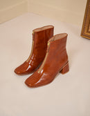 Heeled boots in cognac patent leather