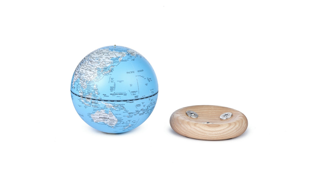 Gingko Design – Atlas Globus Lampe - Hellblau / Sockel Weiße Esche - Mini, ein blauer Globus und ein Sockel aus hellem Holz auf weißem Hintergrund