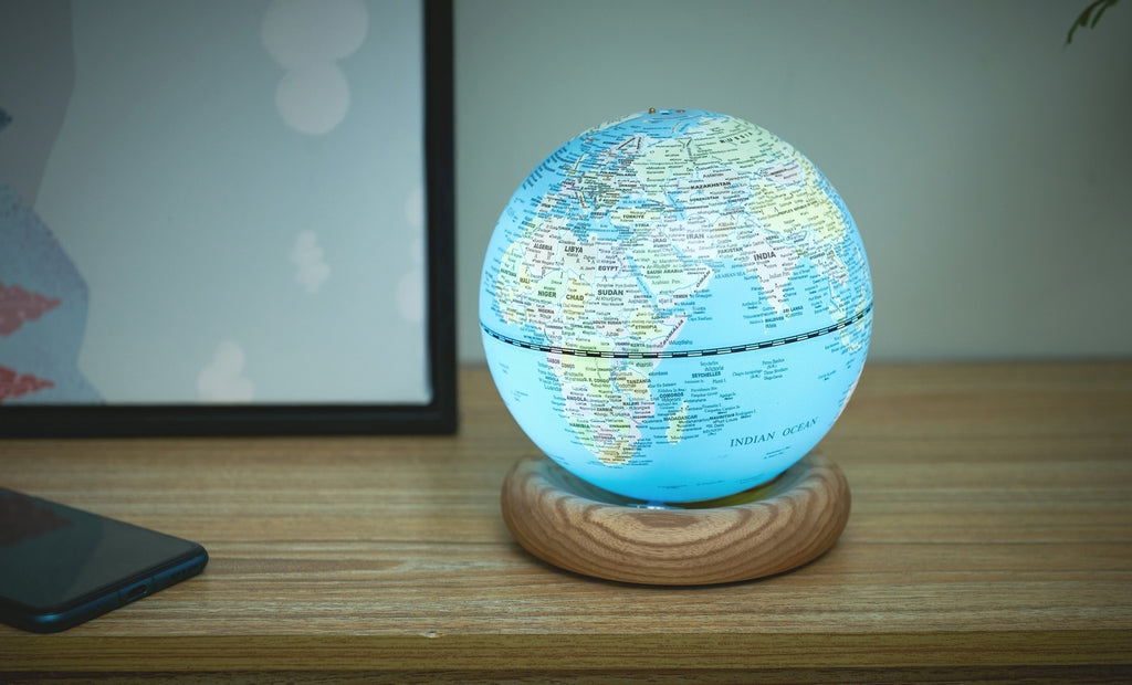 Gingko Design – Atlas Globus Lampe - Hellblau / Sockel Weiße Esche - Mini, ein leuchtender Globus auf einem Holzsockel