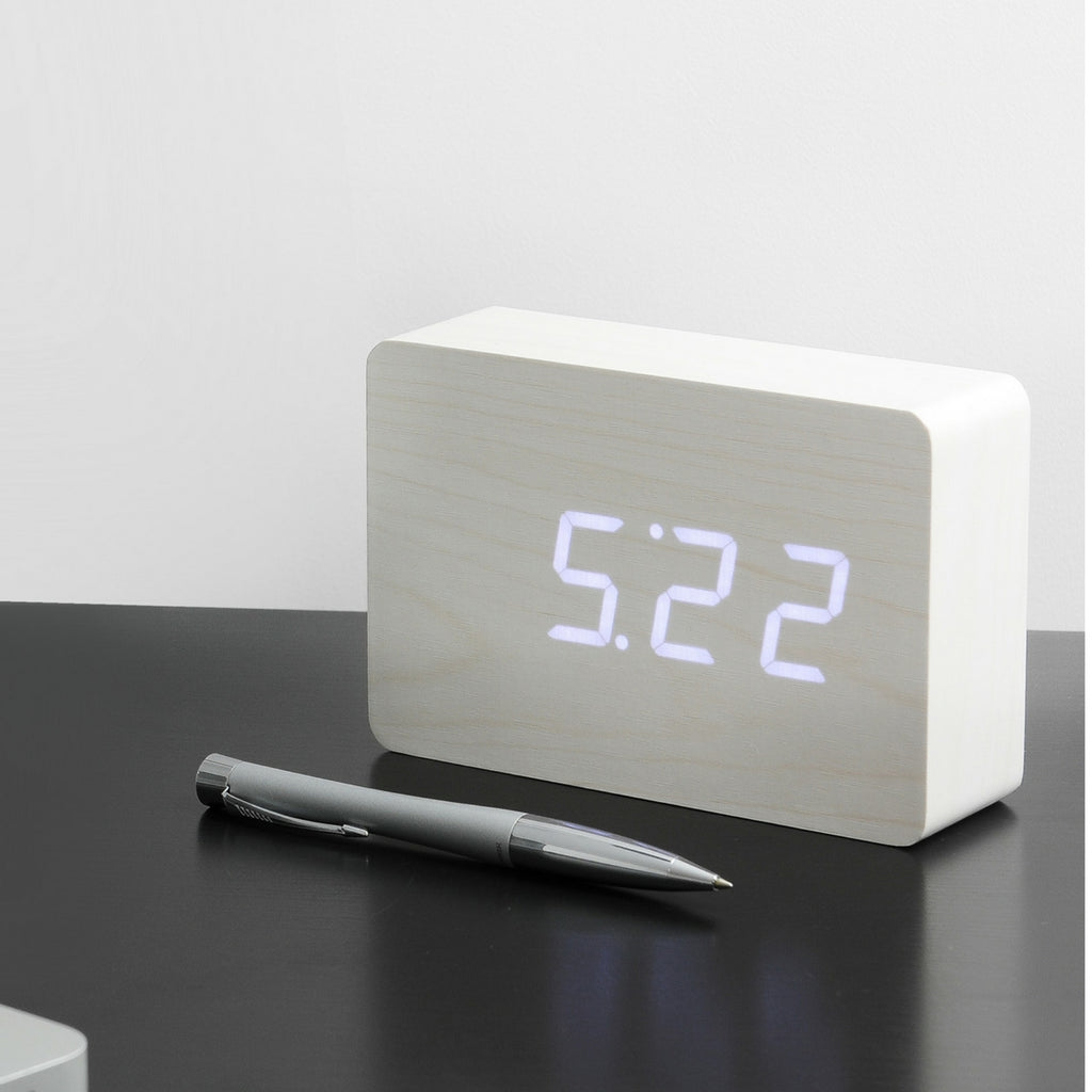 Gingko Design – Brick Click Alarm Clock - White / White LED, light wood digital alarm clock placed on a black table
