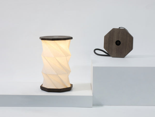 Gingko Design – Luz Twist Hexagon - Nogal Flotado - Mini, lámpara plegable en acordeón encendida y su base de madera oscura