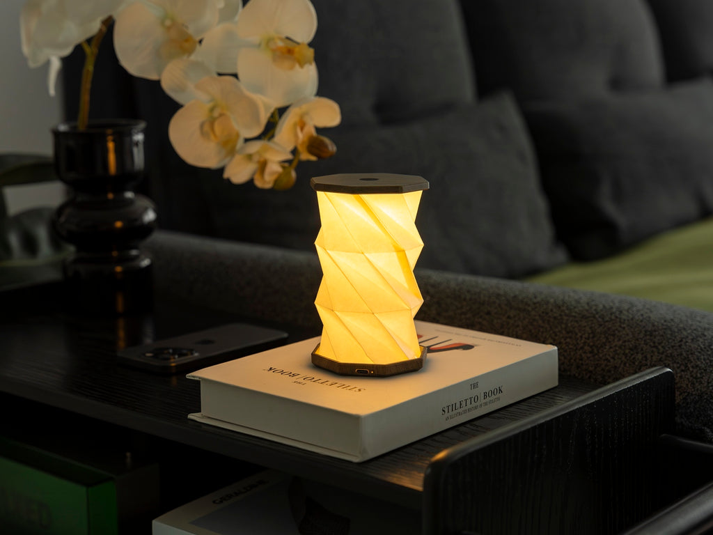 Gingko Design – Twist Hexagon Leuchte - Treibholz Walnuss - Mini, faltbare Tischleuchte beleuchtet einen Nachttisch im Schlafzimmer