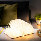 Gingko Design – Lampa Smart Book LED - Len Pudrowy Róż - 2 Rozmiary, lampa w kształcie otwartej książki, stojąca na stoliku w salonie