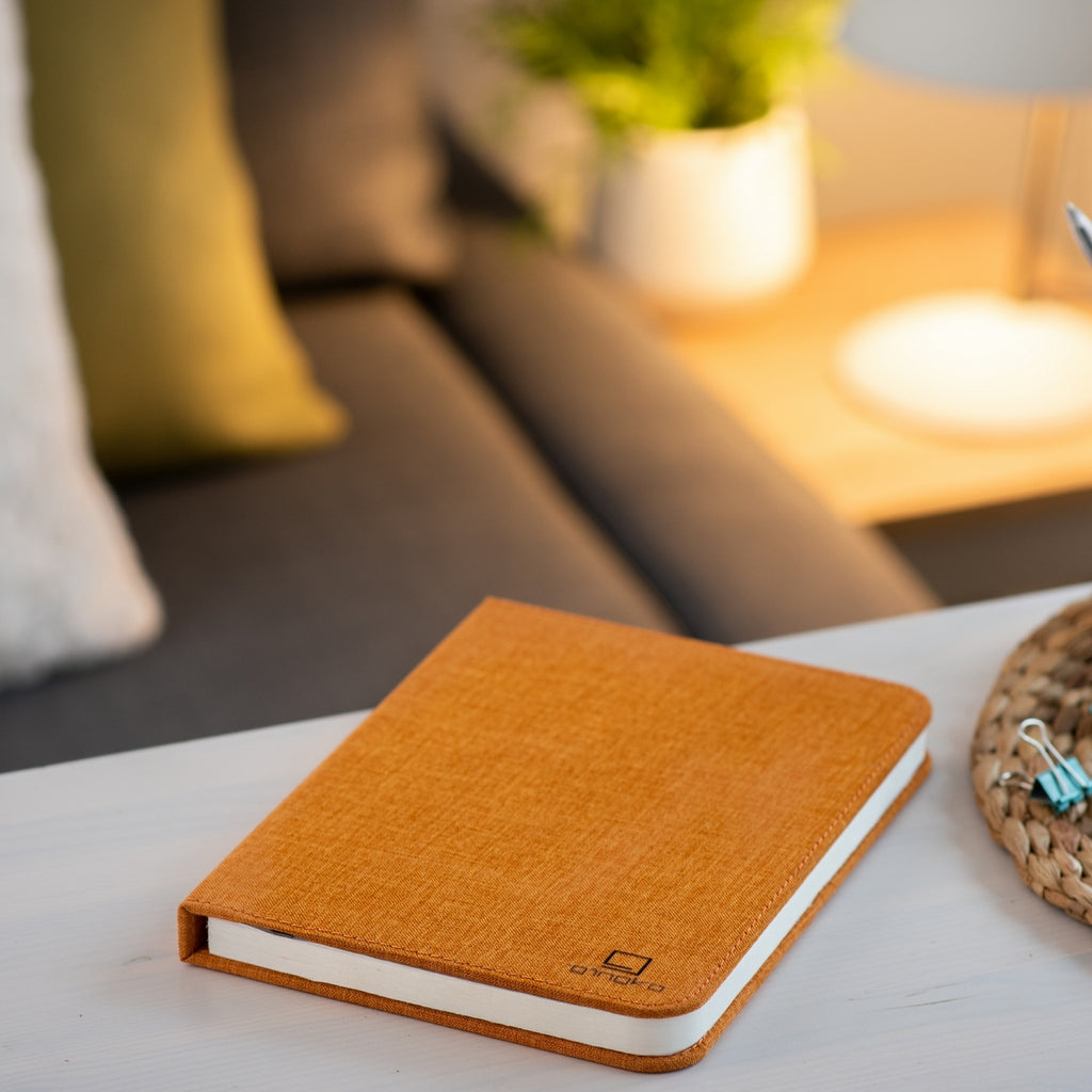Gingko Design – Lampa LED Smart Book – Len Orange Harmony – 2 rozmiary, pomarańczowy notes leżący na stoliku kawowym w salonie