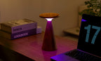 Gingko Design – Sylva Tischleuchte - Walnuss - 2 Größen, Tischleuchte aus Holz mit violettem Licht auf einem Schreibtisch
