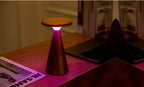 Gingko Design – Sylva Tischleuchte - Walnuss - 2 Größen, Tischleuchte aus Holz mit rosa Licht auf einem Schreibtisch