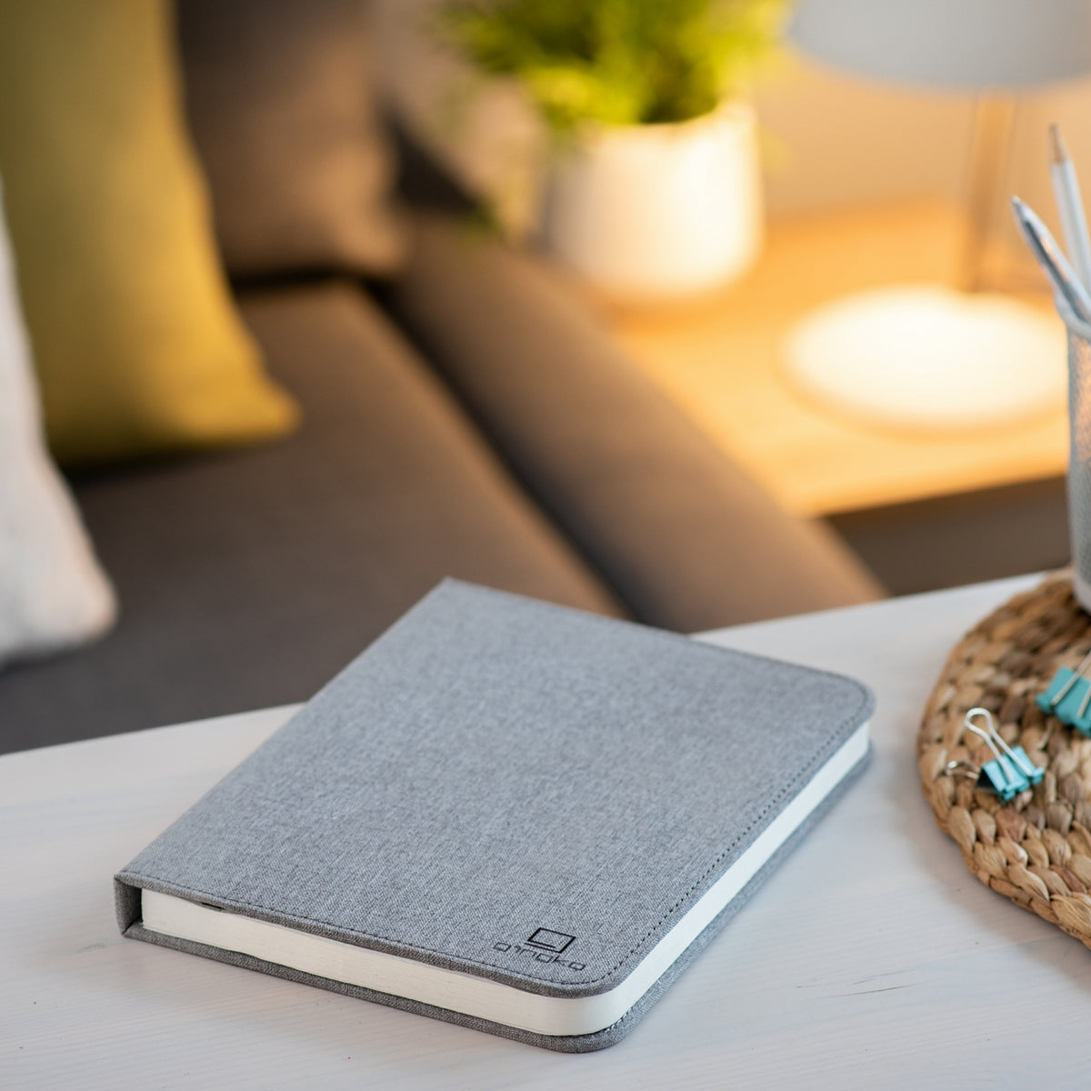 Gingko Design – Lampa Smart Book LED - Len Miejski Szary - 2 Rozmiary, szary notes leżący na stoliku kawowym w salonie