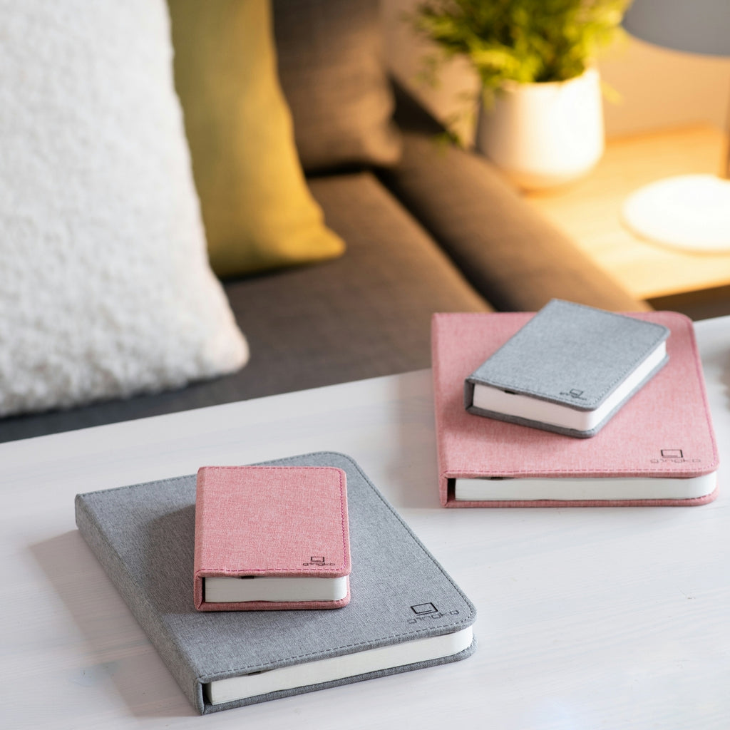 Gingko Design – Lampa Smart Book LED - Len Miejski Szary - 2 Rozmiary, dwa notesy i dwa mininotesy różowe i szare leżące na stole
