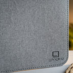 Gingko Design – Lampa Smart Book LED - Len Miejski Szary - 2 Rozmiary, zbliżenie na szarą tkaninę z czarnym logo w prawym dolnym rogu