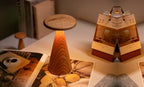 Gingko Design – Sylva Tischleuchte - Weiße Esche - 2 Größen, Tischleuchte aus Holz mit warmem Licht, auf einem aufgeschlagenen Buch platziert