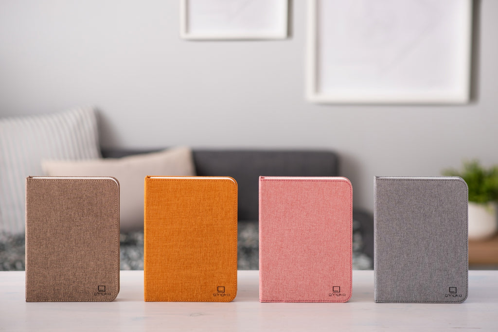 Gingko Design – Lampa Smart Book LED - Len Pudrowy Róż - 2 Rozmiary, cztery notesy w różnych kolorach leżące na białym stole