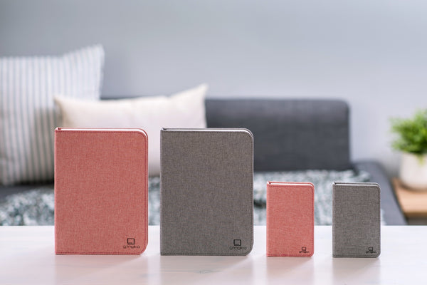 Gingko Design – Lámpara Smart Book LED - Lino Gris Urbano - 2 Tamaños, cuatro cuadernos de notas de diferentes tamaños y colores sobre una mesa