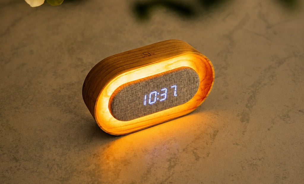 Gingko Design – Lumos Uhr - Oval Weiße Esche, Wecker aus hellem Holz mit digitaler Zeitanzeige auf einem Tisch