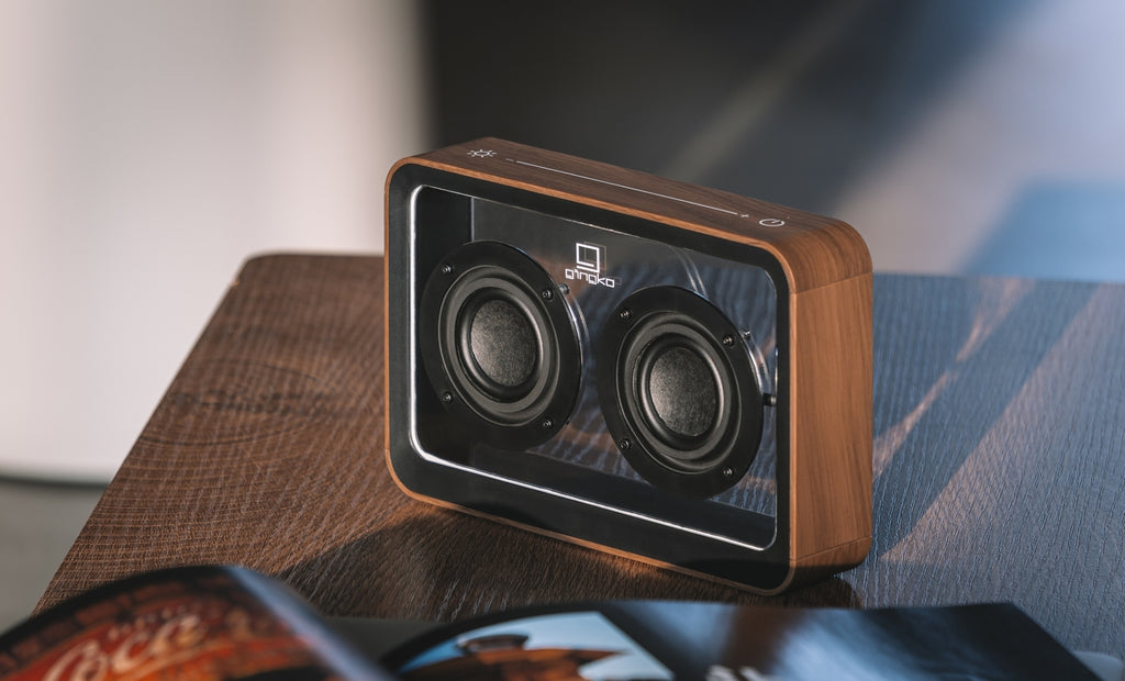 Gingko Design – Przezroczysty głośnik Bluetooth Mage – Orzech, głośnik Bluetooth z drewna i metalu stojący na drewnianym stole