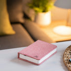 Gingko Design – Lampa Smart Book LED - Len Pudrowy Róż - 2 Rozmiary, różowa książka leżąca na stoliku kawowym w salonie